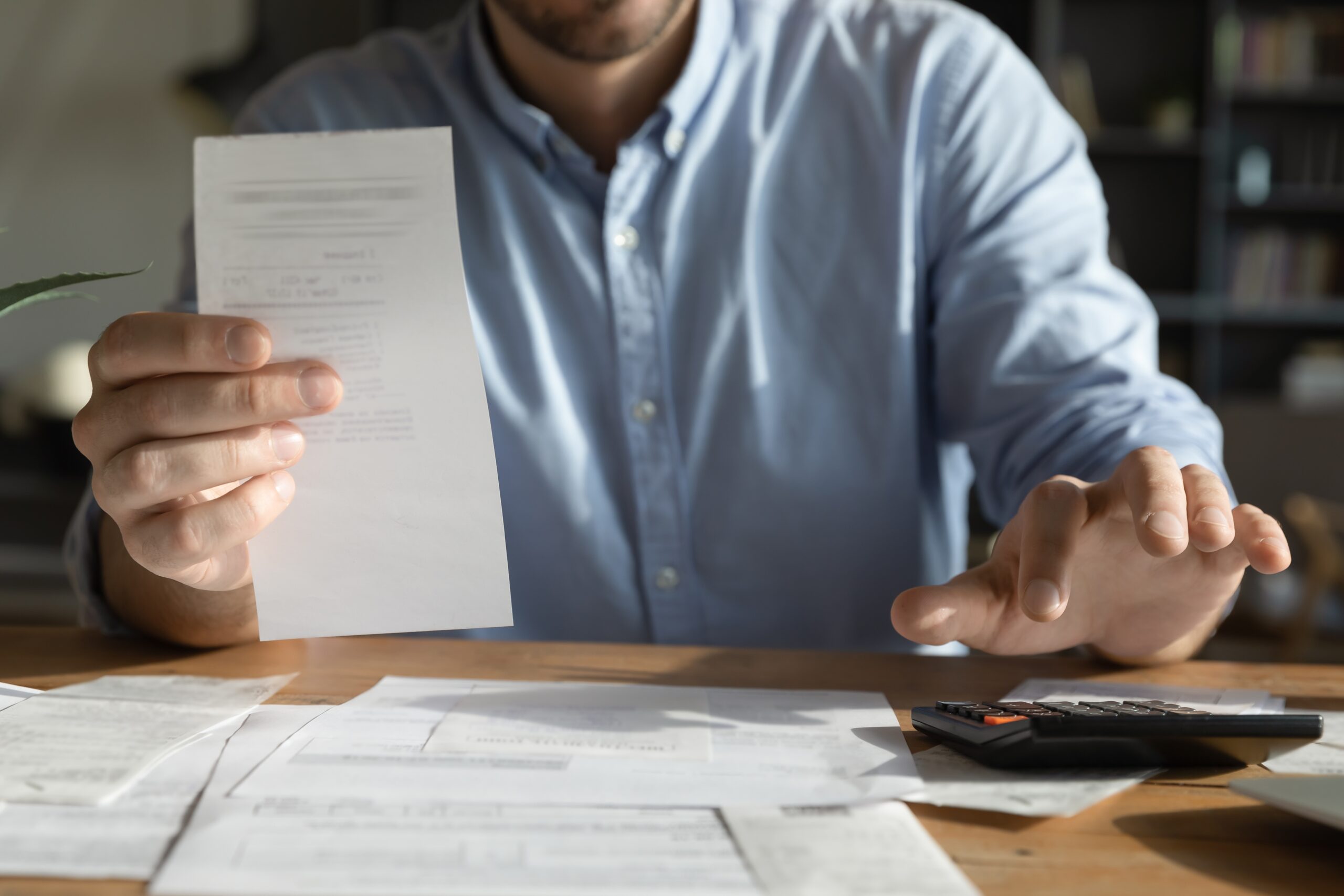 A person reading a bill and using a calculator