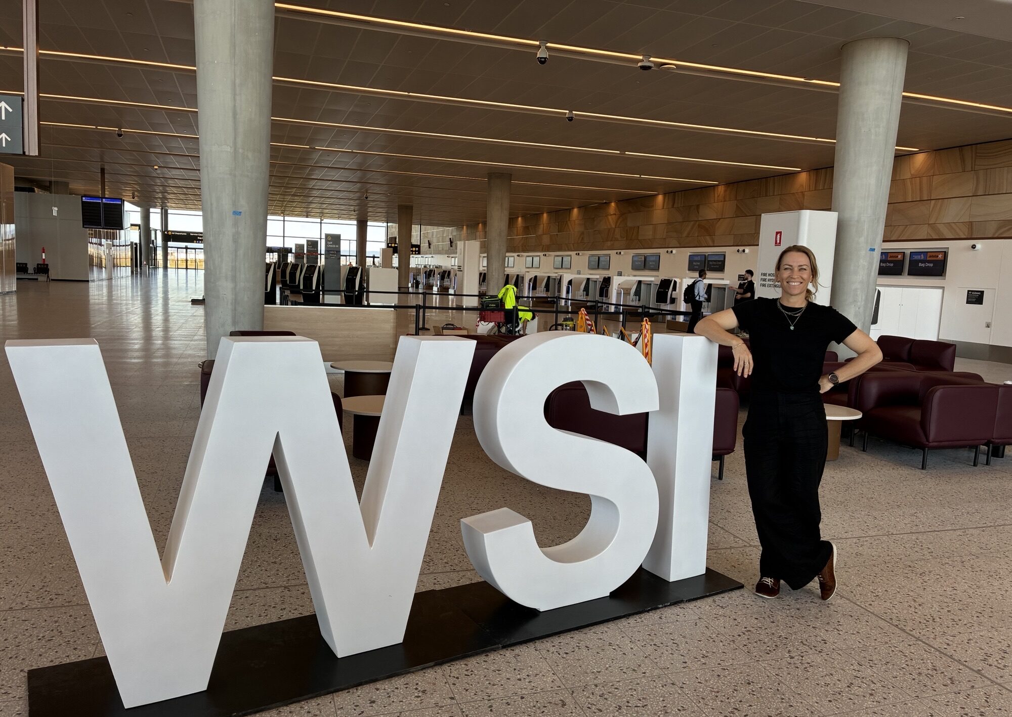 Kim Carland, Hunter Joint Organisation Advocacy and Government Relations Lead, in front of the Western Sydney International Airport sign